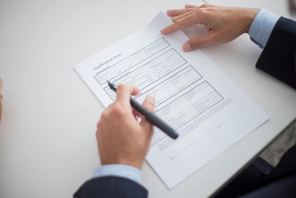 Close-up of a business professional reviewing an application form at a desk.
